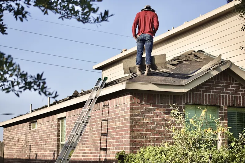 Professional roofer working on a residential roof in Fenway